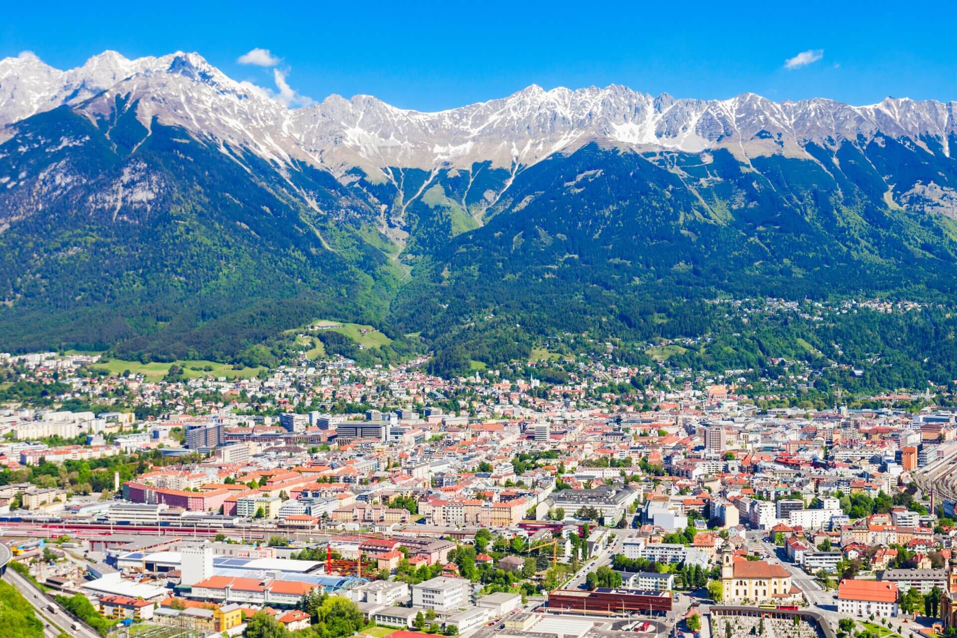 Innsbruck set fra luften med floden Inn, byens tage og bjergene i Nordkette bagved