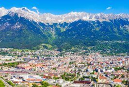 Innsbruck set fra luften med floden Inn, byens tage og bjergene i Nordkette bagved