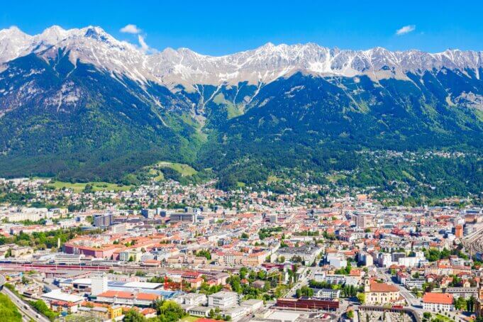 Innsbruck set fra luften med floden Inn, byens tage og bjergene i Nordkette bagved