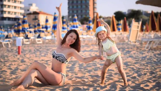 Mor og barn på badestrand i Rimini, Italien