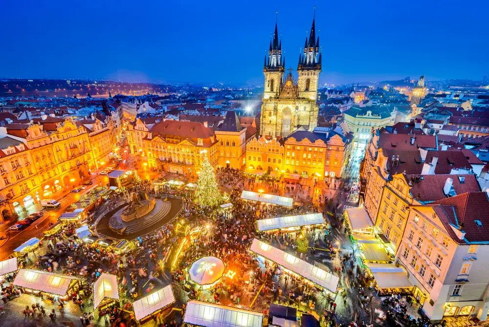 Julemarked i Prag på den gamle rådhusplads med juletræ og Týn-kirken – togrejse til julemarked i Europa