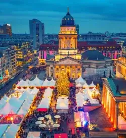 Julemarked i Berlin på Gendarmenmarkt med juletræ og lysende boder – togrejse til julemarked i Europa