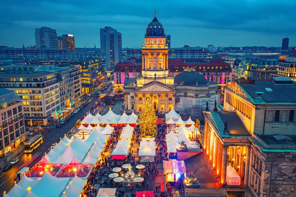 Julemarked i Berlin på Gendarmenmarkt med juletræ og lysende boder – togrejse til julemarked i Europa