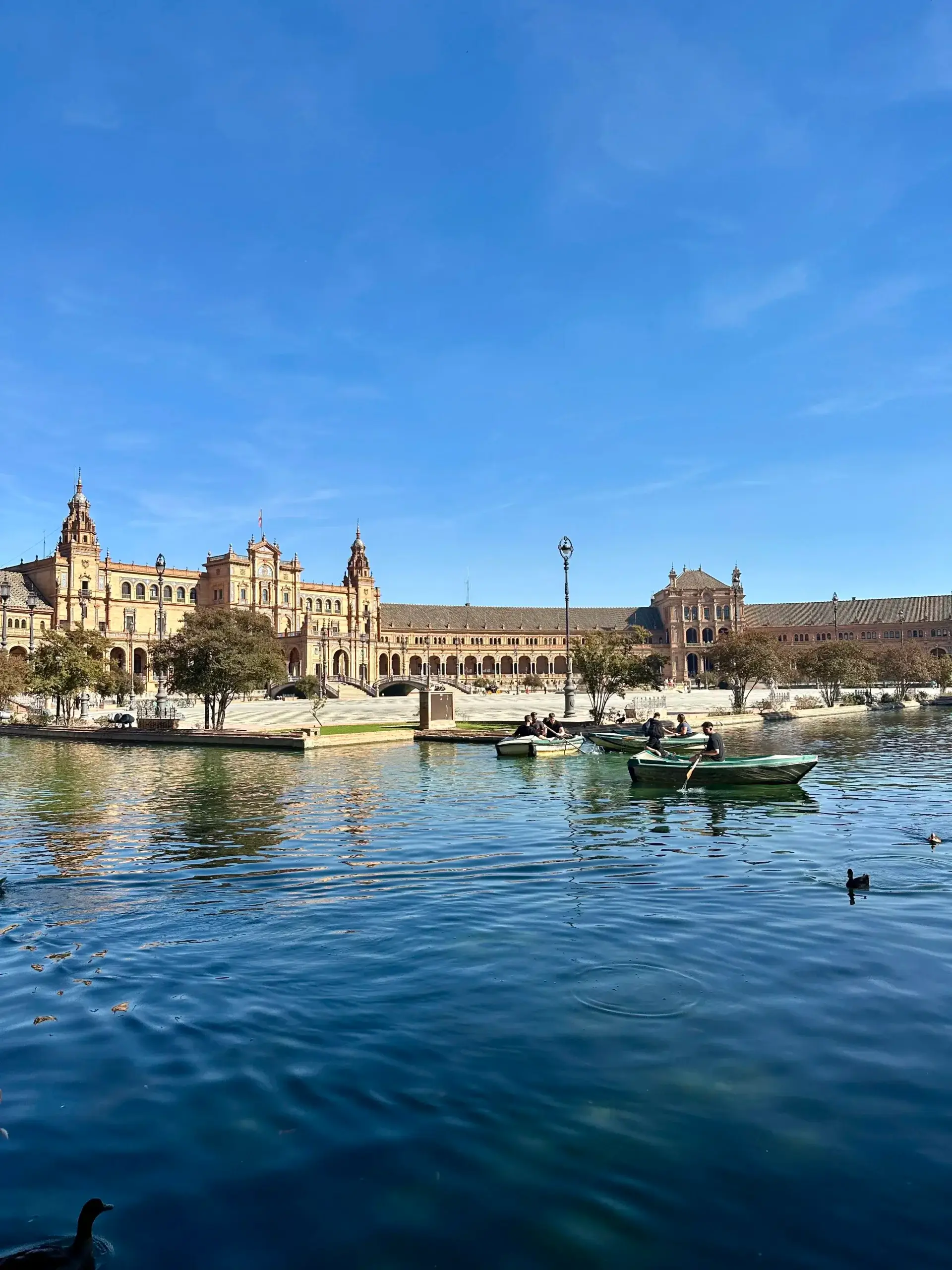 Mennesker i robåde på kanalen ved Plaza de España i Sevilla