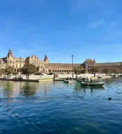 Mennesker i robåde på kanalen ved Plaza de España i Sevilla