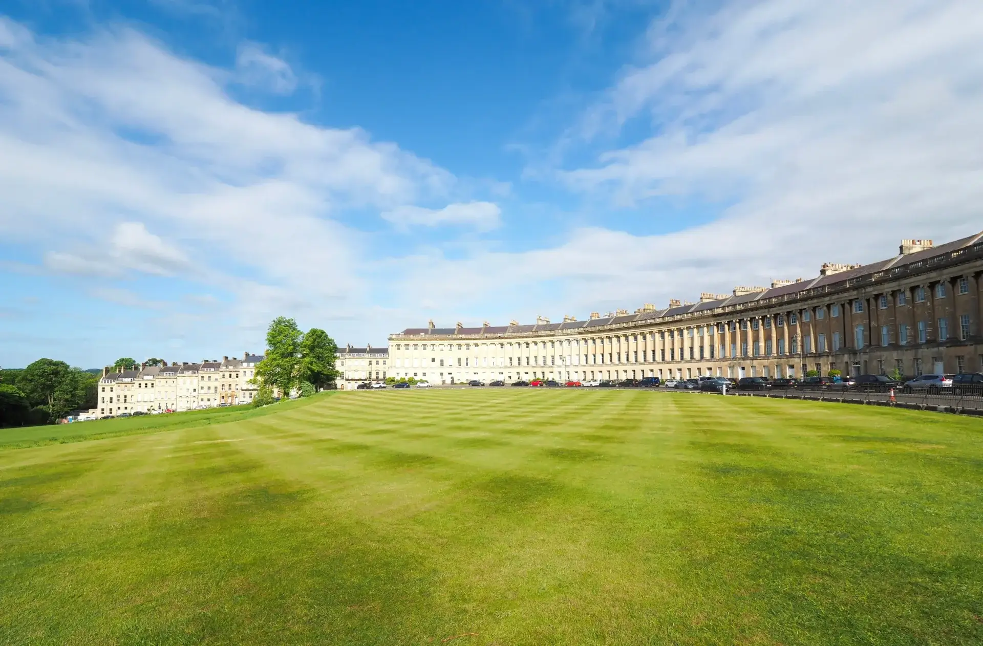 Royal Crescent i Bath med grøn plæne og blå himmel