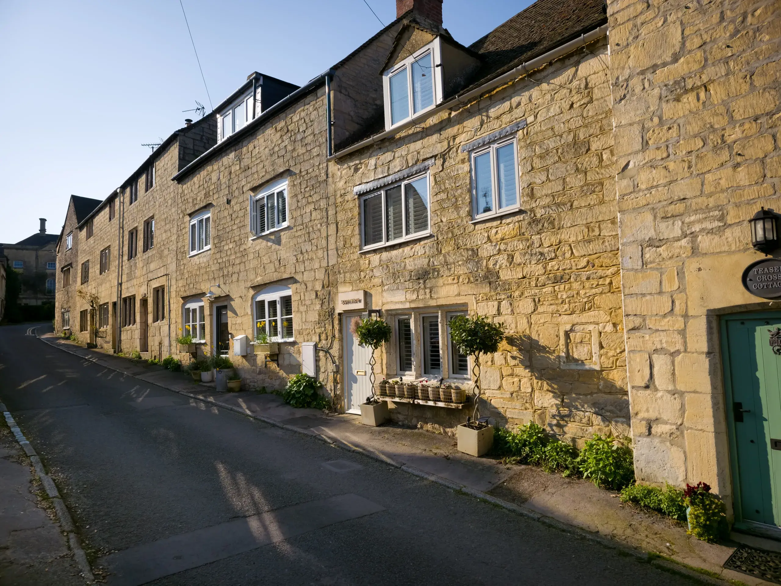 Gamle stenhuse af gul kalksten i en landsby i Cotswolds