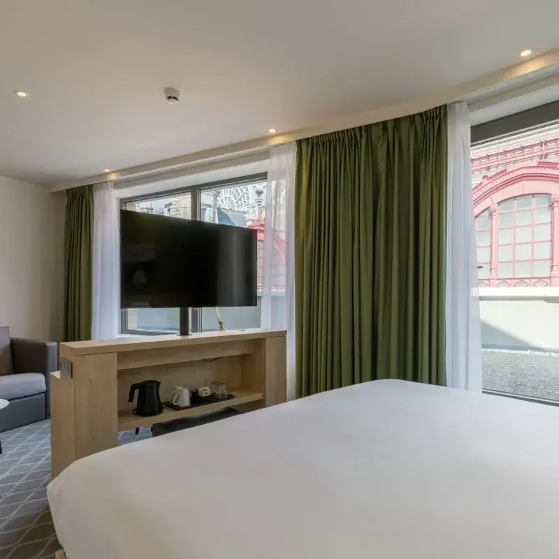Værelse med sofa og dobbeltseng på Hampton by Hilton Antwerp Central Station