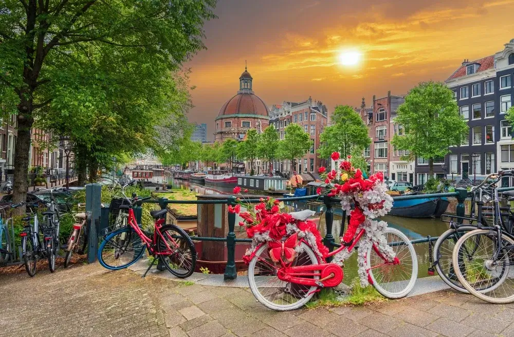 Cykel pyntet med røde blomster på en bro over Singel-kanalen i Amsterdam