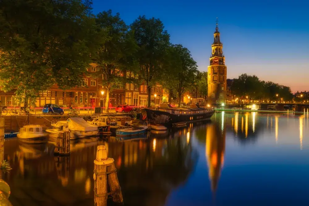 Montelbaanstoren og kanalen i Amsterdam oplyst i den blå time