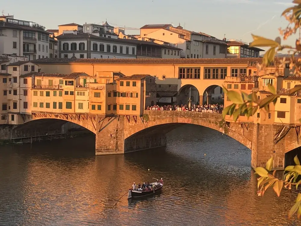 Ponte Vecchio over Arno-floden i Firenze i gyldent aftenlys