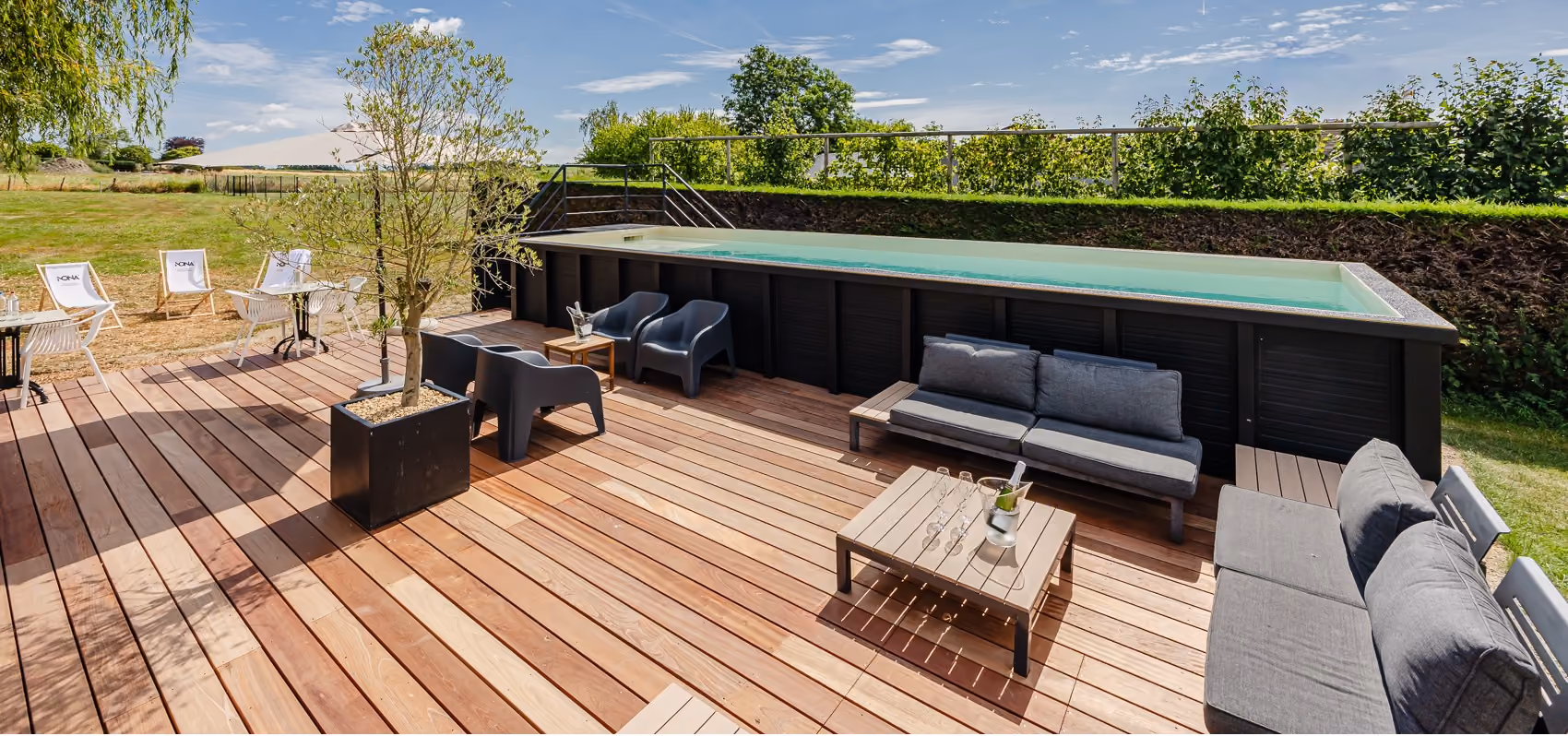Opvarmet udendørspool og solterrasse med udsigt over markerne ved Maison Pal'Ange i Ardennerne