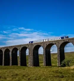 Tog kører over Ribblehead-viadukten i Yorkshire Dales