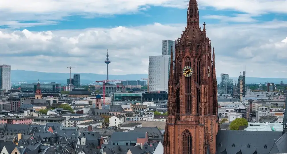 Kejserdomkirkens gotiske tårn i rød sandsten over Frankfurts tage med skyskrabere og tv-tårnet i baggrunden