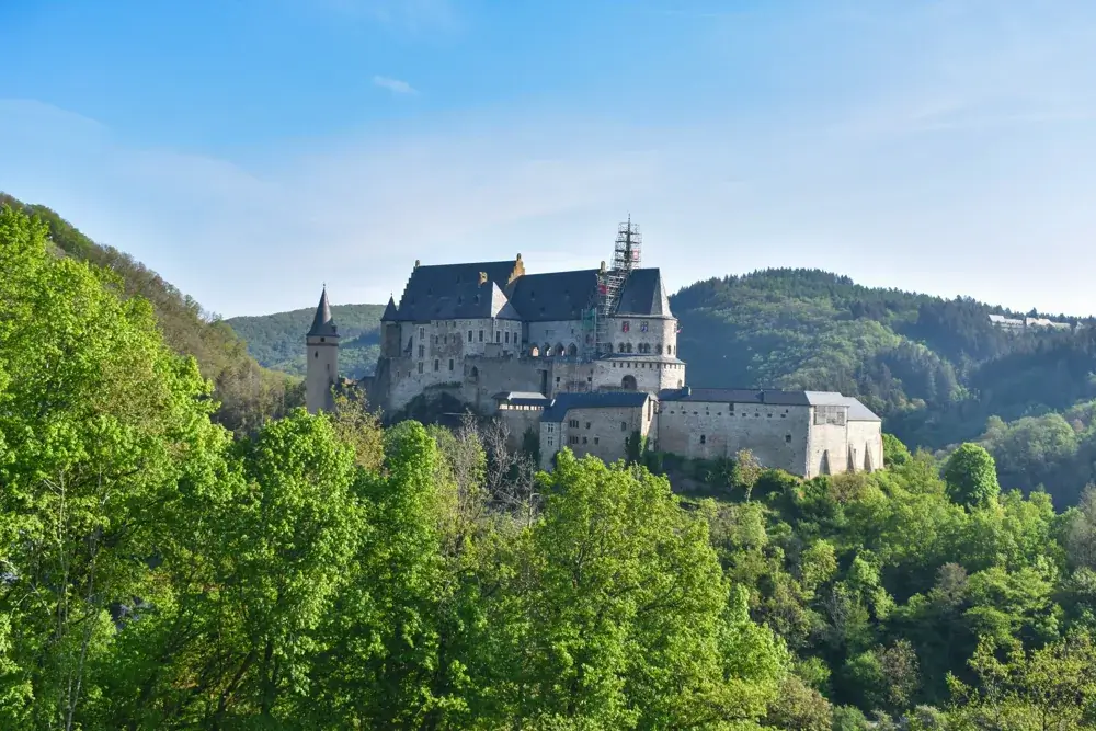 Vianden slot på skovklædt bakke i Luxembourg