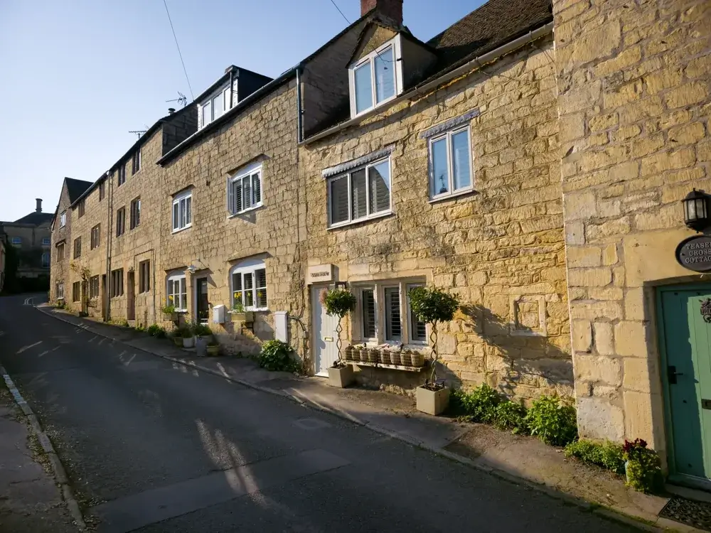 Gamle stenhuse af gul kalksten i en landsby i Cotswolds