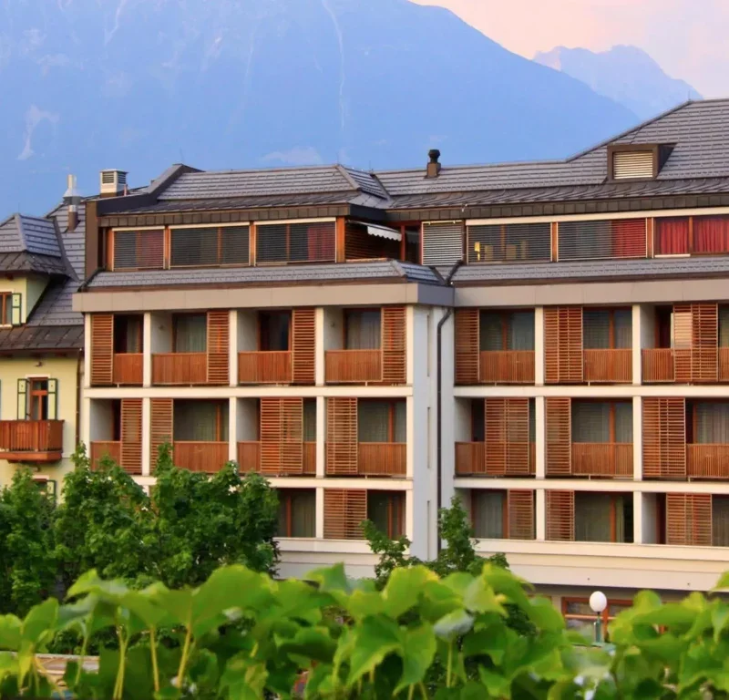 Facaden på Hotel Kompas i Bled med altaner og bjerge bagved
