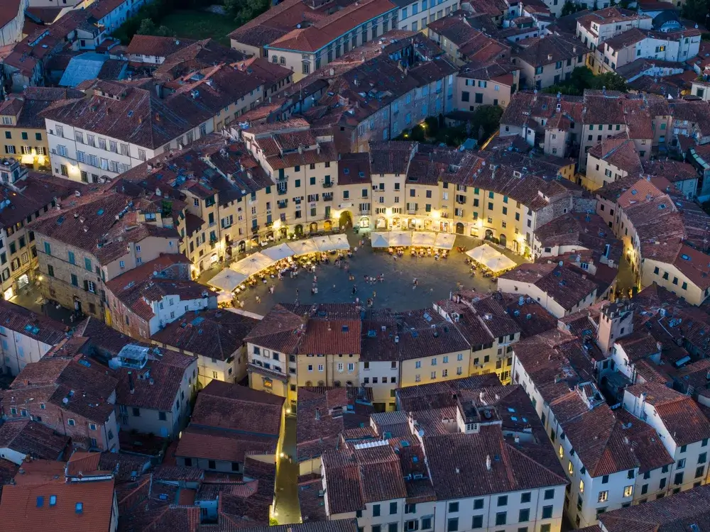 Den ovale plads Piazza dell'Anfiteatro i Lucca set fra luften i den blå time