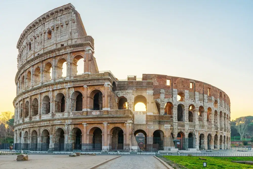 Colosseum i Rom i blødt morgenlys med tom plads foran