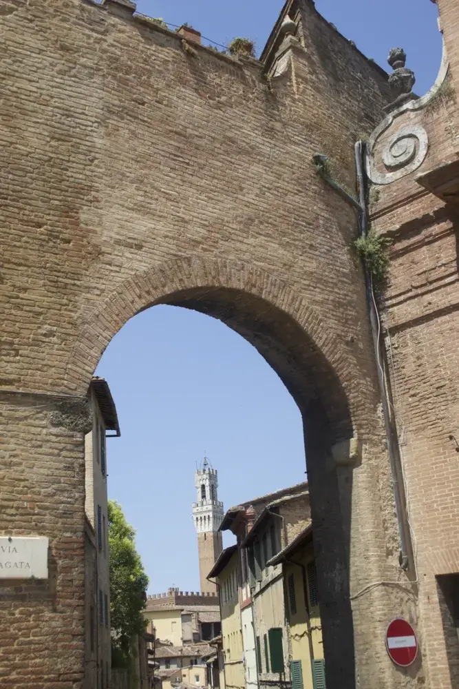 Tårnet Torre del Mangia set gennem en middelalderlig port i Siena