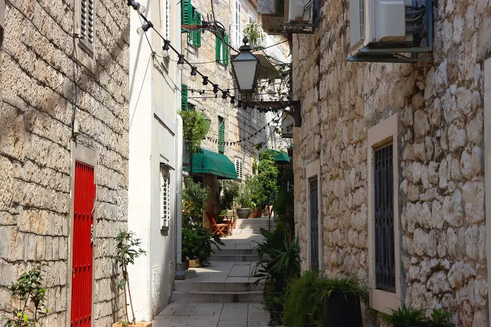 Smal stenbelagt gade med stenhuse i den gamle bydel i Makarska, Kroatien