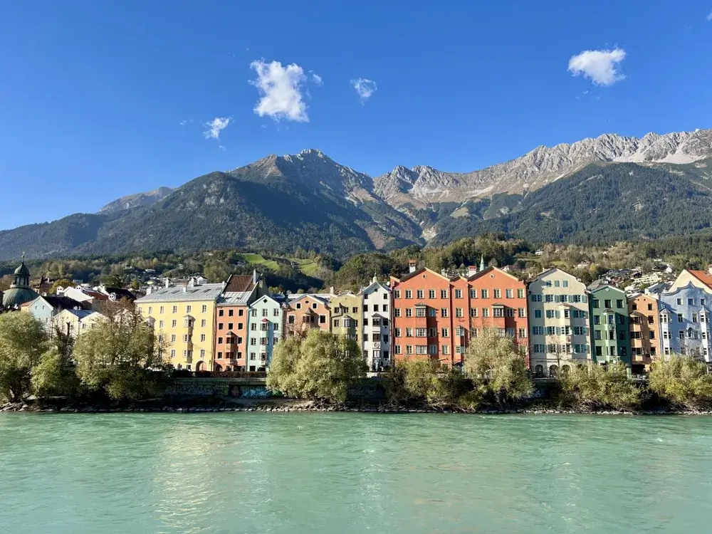 Farverige huse langs floden Inn i Innsbruck med Nordkette-bjergene bagved