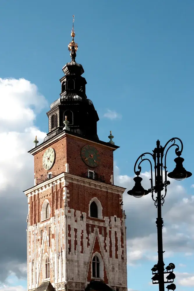 Rådhustårnet på markedspladsen i Krakow med en gammel gadelygte
