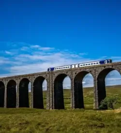Tog kører over Ribblehead-viadukten i Yorkshire Dales