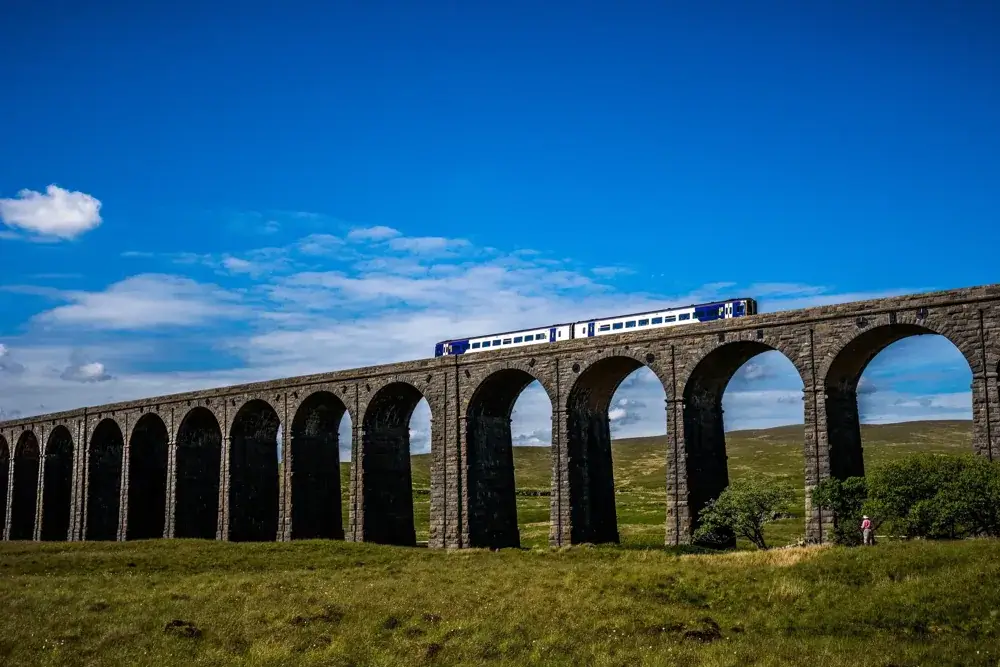 Tog kører over Ribblehead-viadukten i Yorkshire Dales