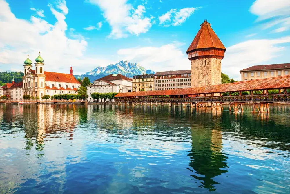 Træbroen Kapellbrücke og vandtårnet over floden Reuss i Luzern med Pilatus i baggrunden