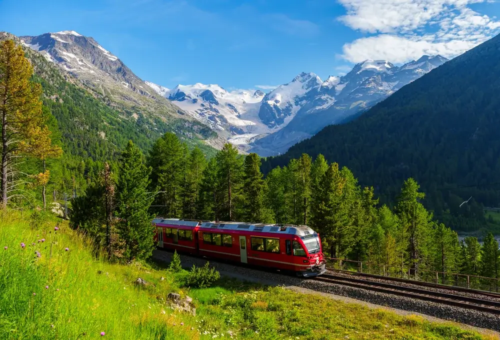 Rødt tog i Engadin med Morteratsch-gletsjeren og de sneklædte bjerge bag
