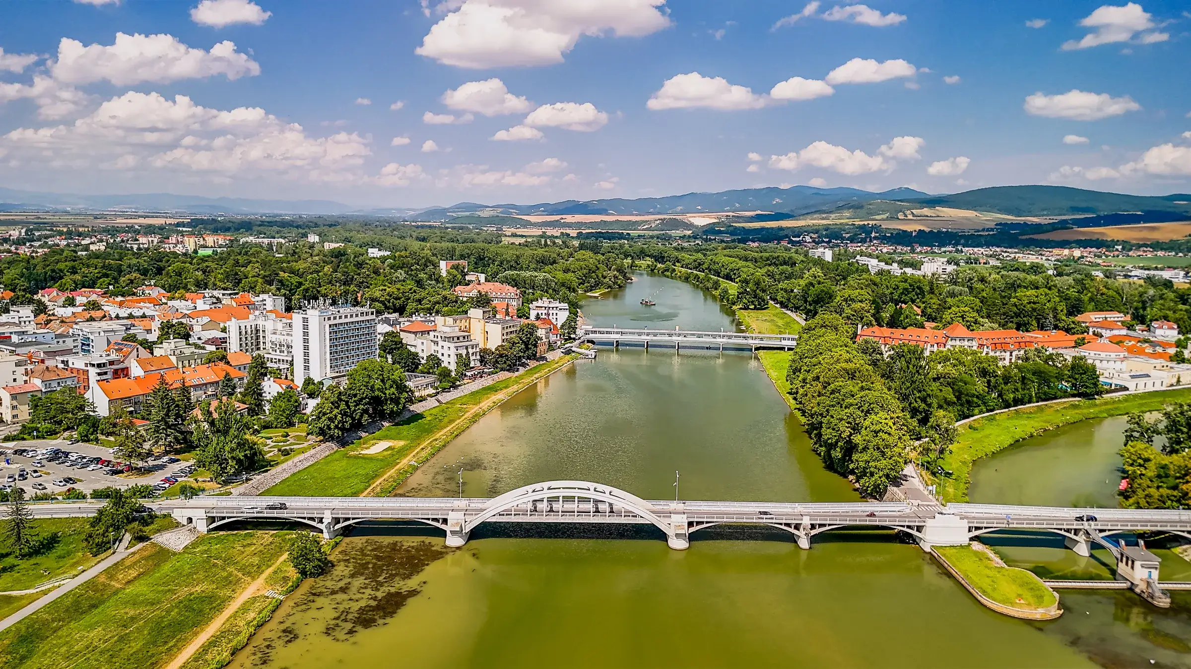 Luftfoto af Piešťany med floden Váh, broerne og kurøen