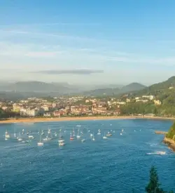 La Concha-bugten i San Sebastián set fra luften med sandstrand, byen og sejlbåde