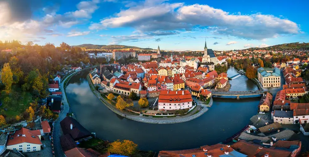 Den gamle by i Český Krumlov i en bue af floden Vltava med slottet og røde tage om efteråret