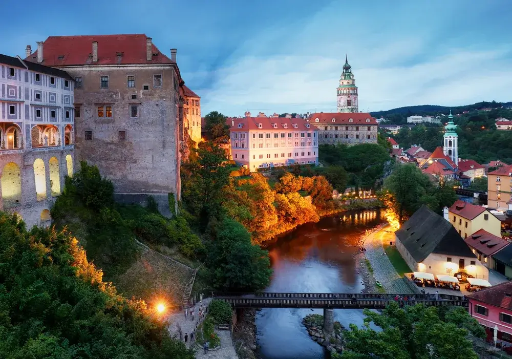 Slottet i Český Krumlov og floden Vltava med en lille bro i aftenlys