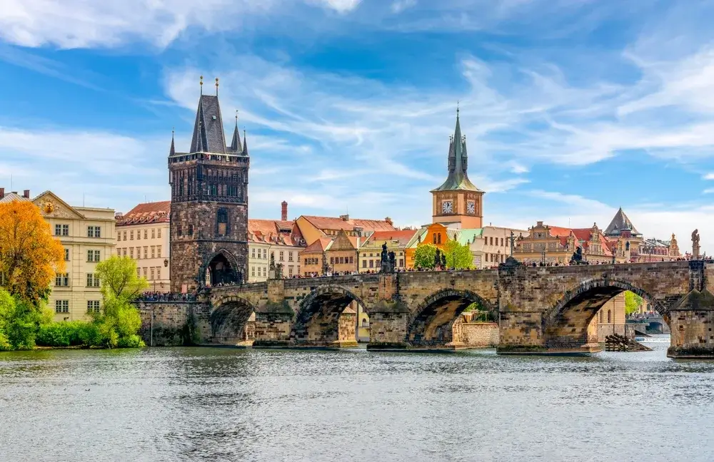 Karlsbroen med det gotiske brotårn set fra Vltava-floden i Prag en sommerdag