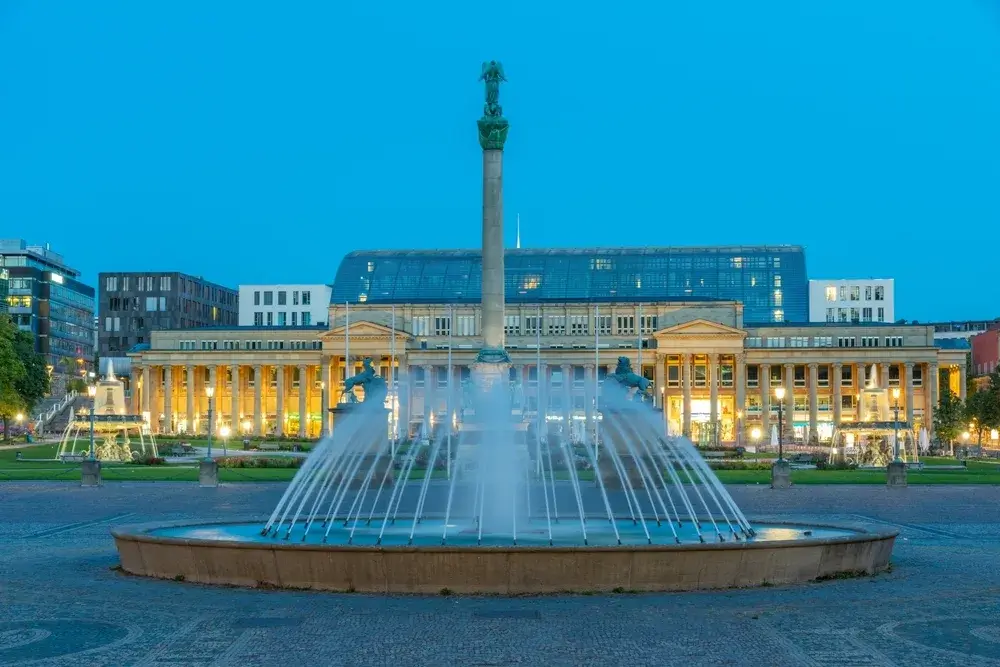 Springvand og Jubilæumssøjlen på Schlossplatz foran Königsbau i Stuttgart i blå time